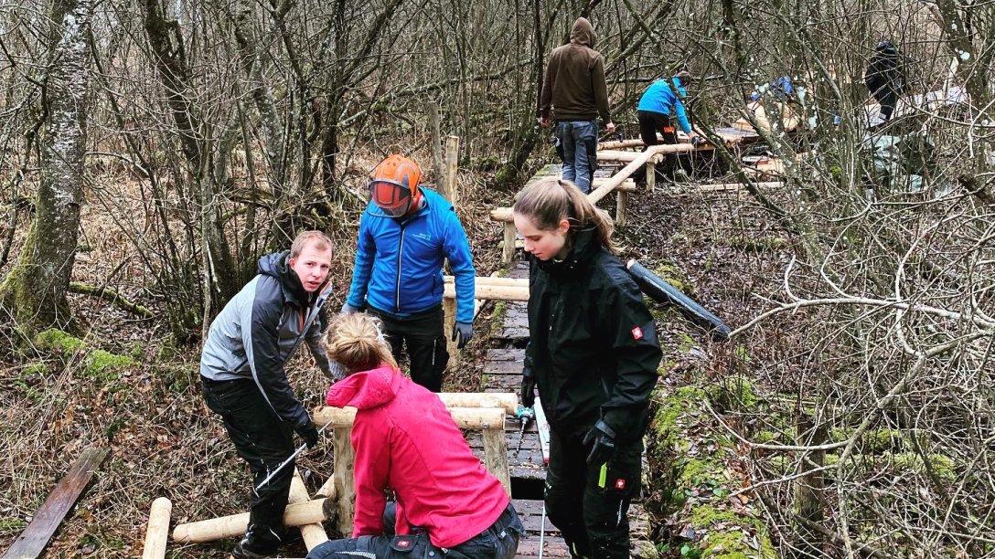 Freiwllige junge Menschen helfen beim Bau eines neuen Pfads im Zentrum für Umwelt und Kultur