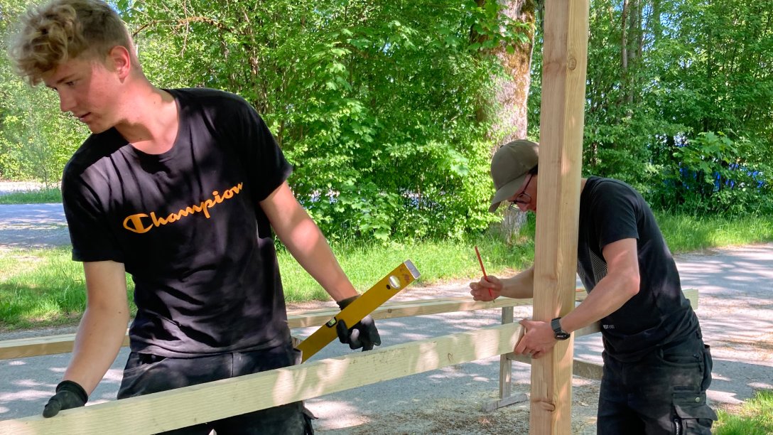 Freiwllige junge Menschen helfen beim Bau eines Holzgerüsts im Zentrum für Umwelt und Kultur