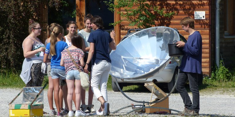 Jugendliche kochen am Solarkocher